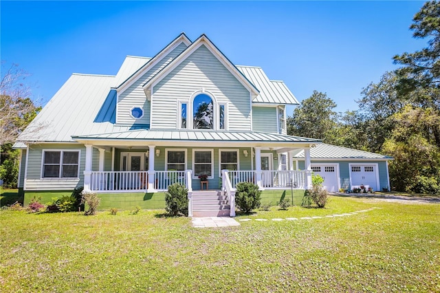 farmhouse inspired home with a front yard, a garage, and covered porch