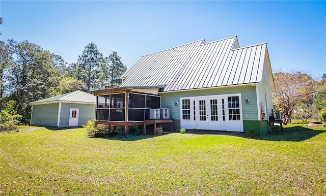 back of property with a yard and a sunroom