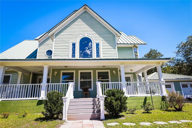 farmhouse featuring a porch and a front yard