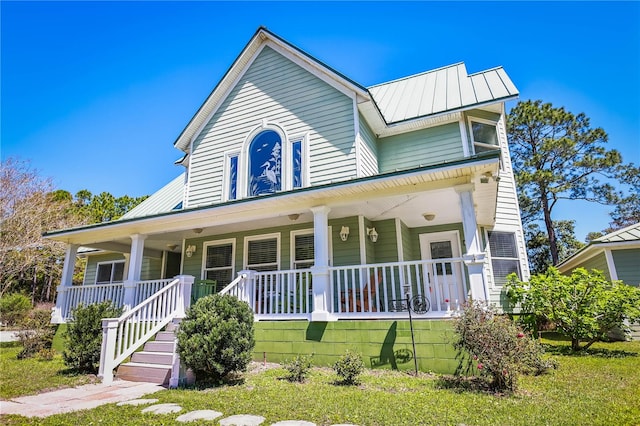 view of front of house with a porch and a front yard