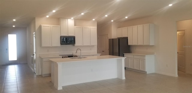 kitchen featuring an island with sink and white cabinets