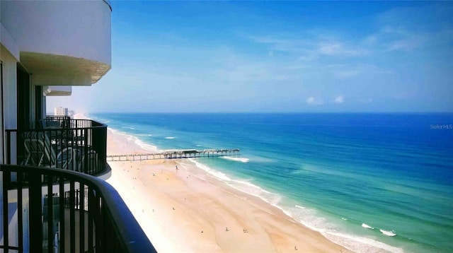 balcony with a water view and a beach view