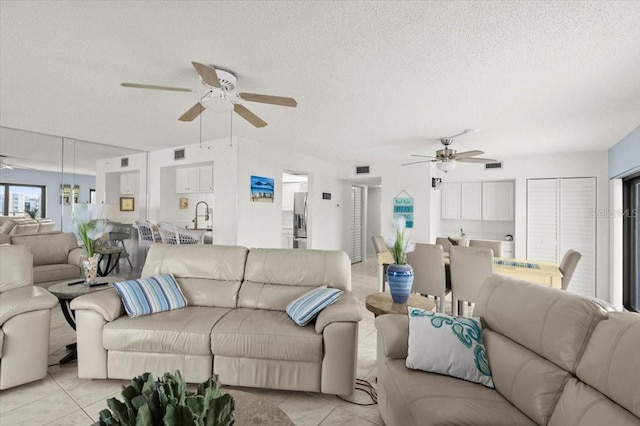 tiled living room featuring ceiling fan and a textured ceiling