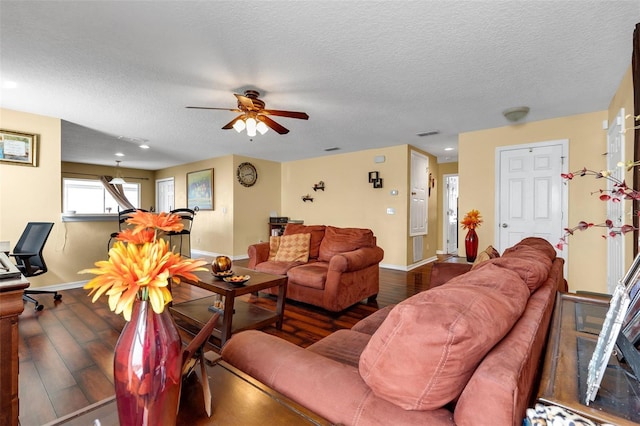 living room featuring hardwood / wood-style flooring, ceiling fan, and a textured ceiling