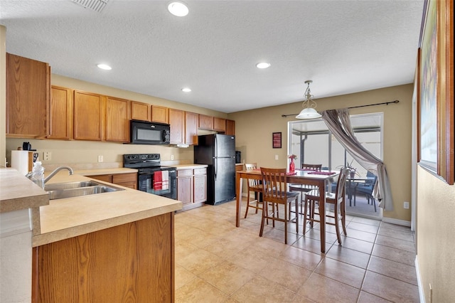 kitchen with hanging light fixtures, a textured ceiling, black appliances, sink, and light tile flooring