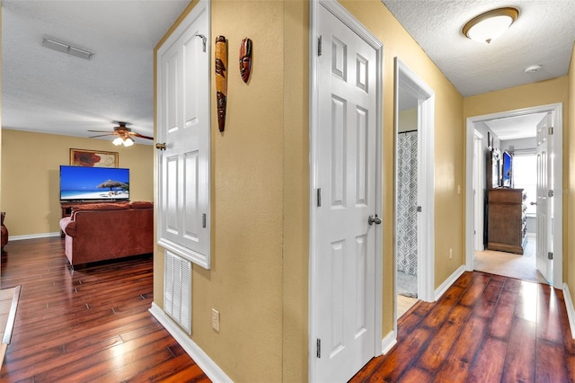 hallway with hardwood / wood-style flooring and a textured ceiling