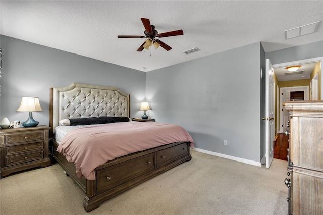 carpeted bedroom featuring a textured ceiling and ceiling fan