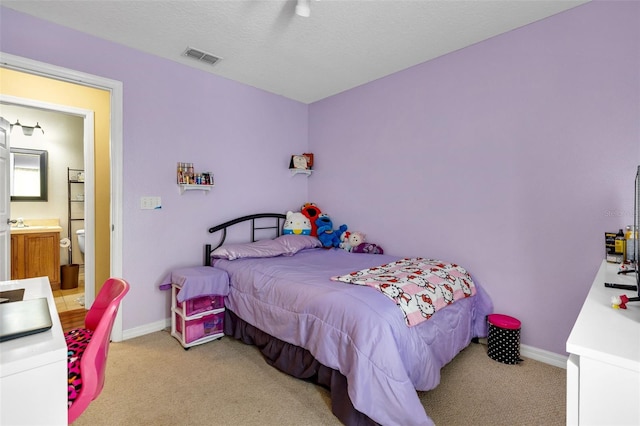 carpeted bedroom featuring ensuite bathroom, ceiling fan, and a textured ceiling