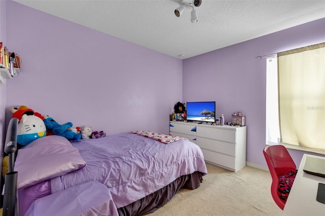 bedroom with a textured ceiling and light colored carpet