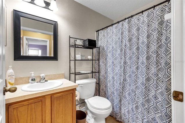 bathroom featuring a textured ceiling, oversized vanity, and toilet