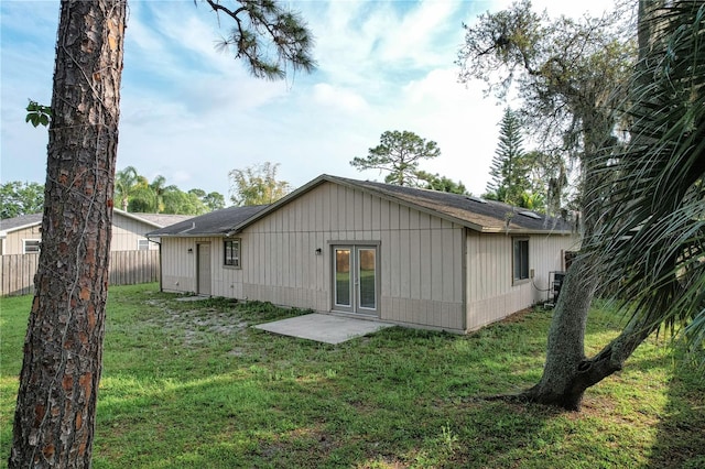 rear view of property featuring a yard and a patio area