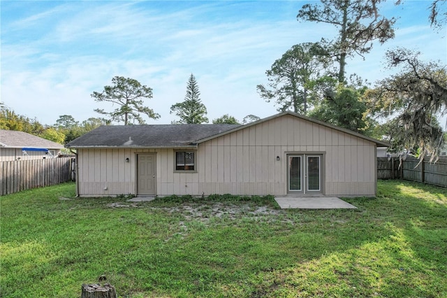 rear view of property featuring a lawn