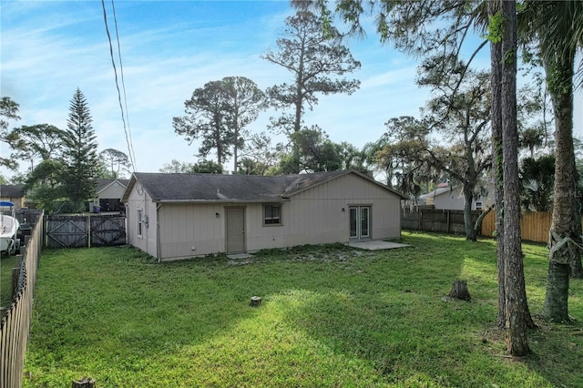 back of house featuring a patio and a lawn