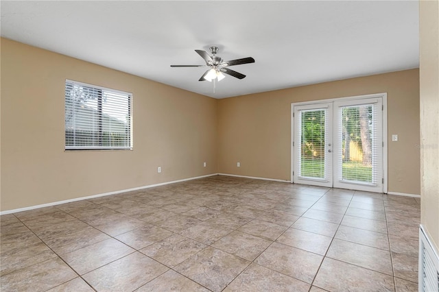 tiled spare room featuring french doors and ceiling fan