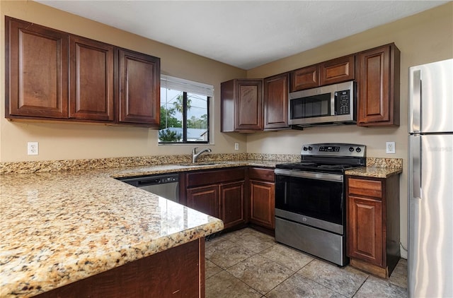 kitchen featuring dark brown cabinets, sink, light tile floors, and stainless steel appliances