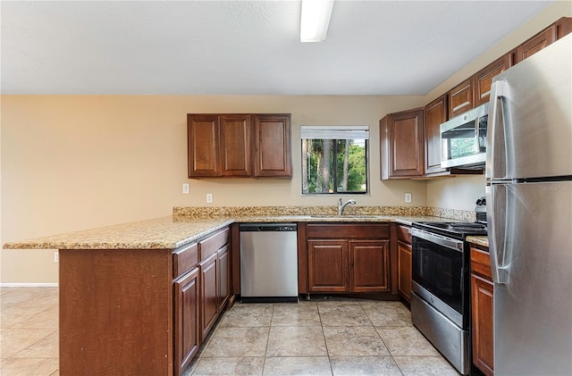 kitchen with kitchen peninsula, appliances with stainless steel finishes, sink, light tile flooring, and light stone counters