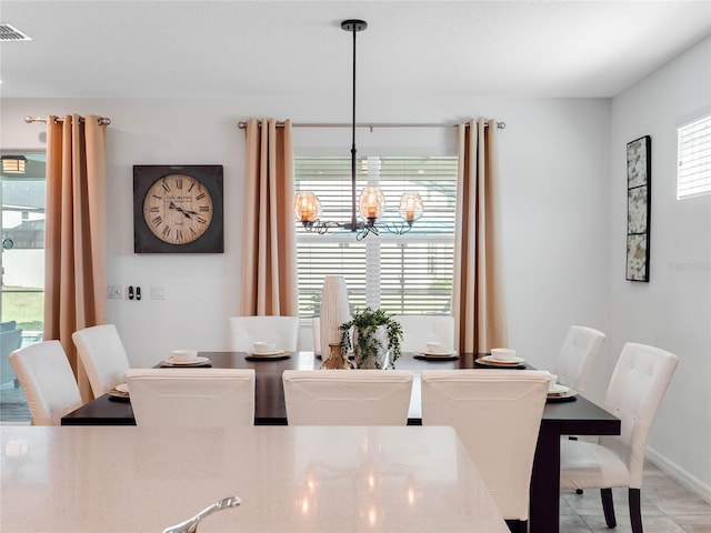 tiled dining area with a chandelier