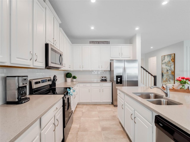 kitchen with light tile flooring, white cabinetry, appliances with stainless steel finishes, and sink