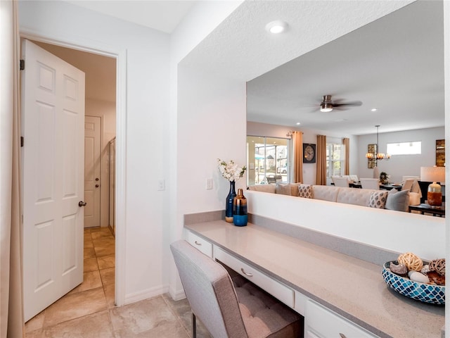 tiled dining space featuring ceiling fan with notable chandelier