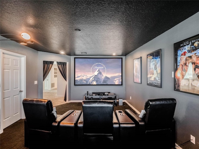 cinema featuring dark colored carpet and a textured ceiling