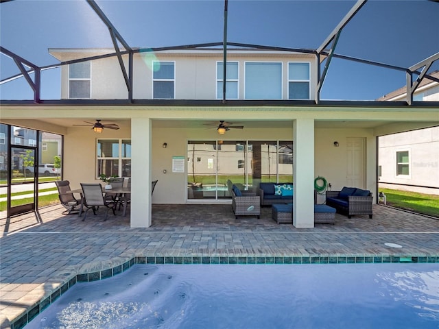 rear view of property featuring a patio area, outdoor lounge area, ceiling fan, and a lanai