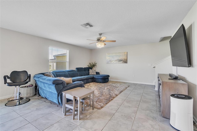 tiled living room with ceiling fan and a textured ceiling