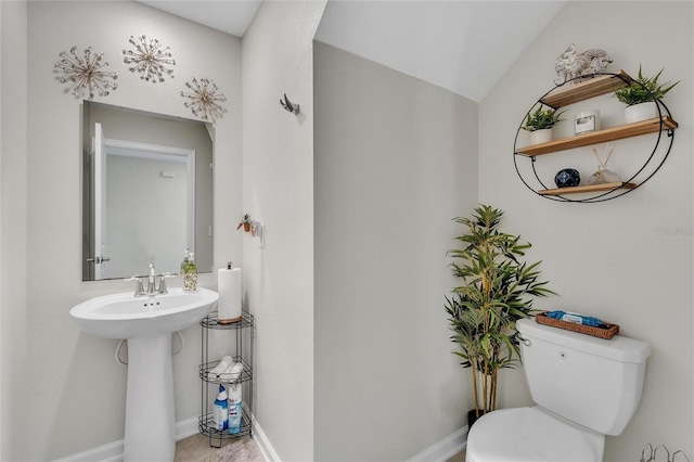 bathroom featuring toilet and lofted ceiling