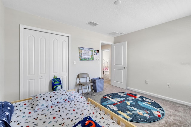 bedroom with light colored carpet, a closet, and a textured ceiling