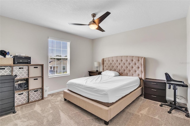 bedroom with light carpet, a textured ceiling, and ceiling fan