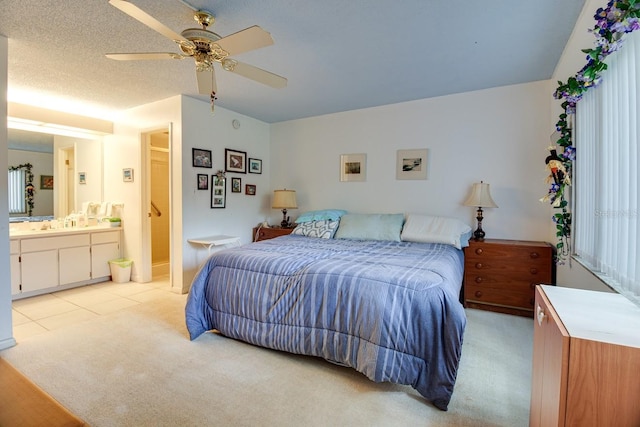 bedroom with light tile floors, ceiling fan, a textured ceiling, and ensuite bathroom