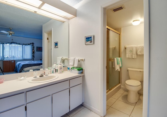 bathroom with toilet, large vanity, ceiling fan, walk in shower, and tile flooring