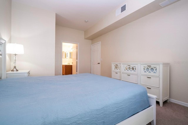 bedroom featuring ensuite bathroom and carpet flooring