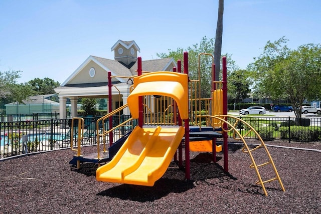 view of playground with a fenced in pool