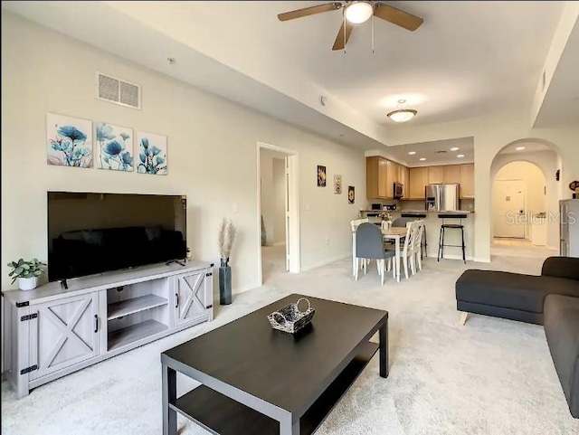 living room featuring light colored carpet and ceiling fan