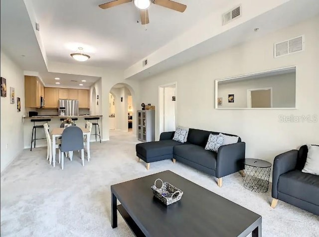 living room featuring light carpet and ceiling fan