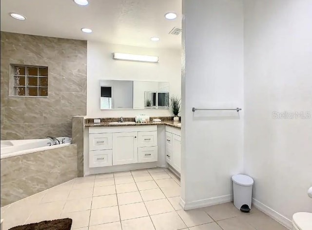 bathroom featuring toilet, vanity, tile floors, and tiled tub