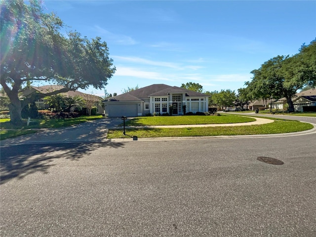 ranch-style house featuring a front yard and a garage