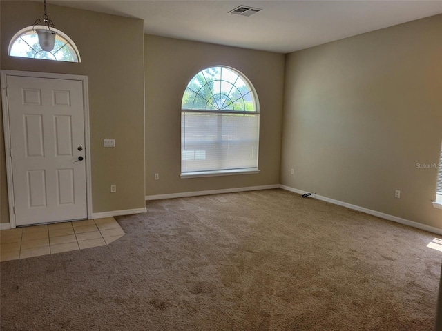 entryway with a wealth of natural light and light colored carpet