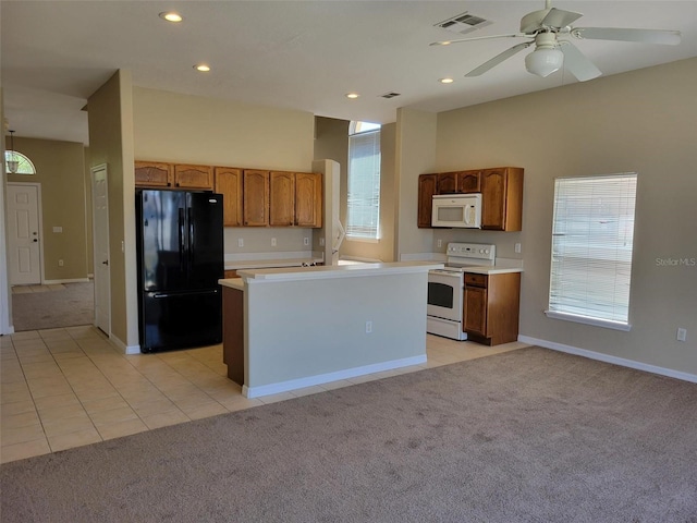 kitchen with light tile flooring, ceiling fan, white appliances, and a kitchen island