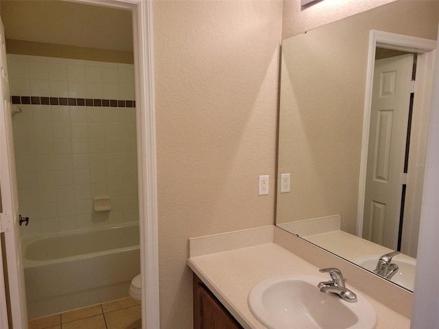 full bathroom featuring tiled shower / bath combo, tile floors, toilet, and vanity