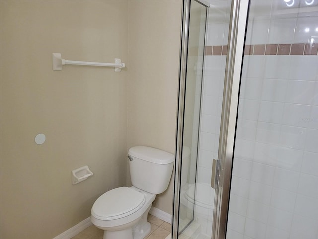 bathroom featuring toilet, tile floors, and a shower with shower door