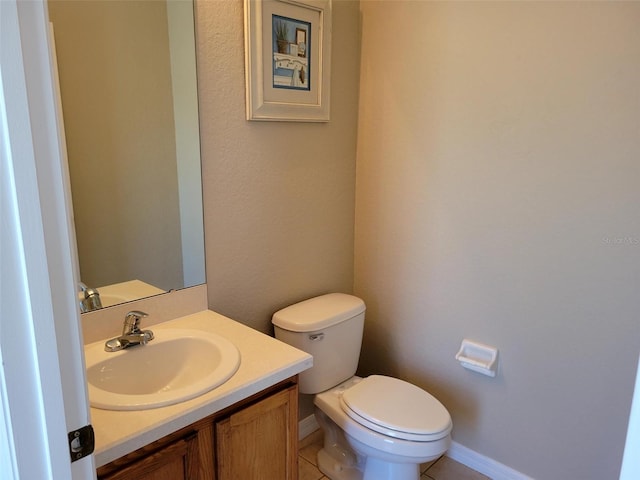 bathroom featuring tile flooring, toilet, and vanity