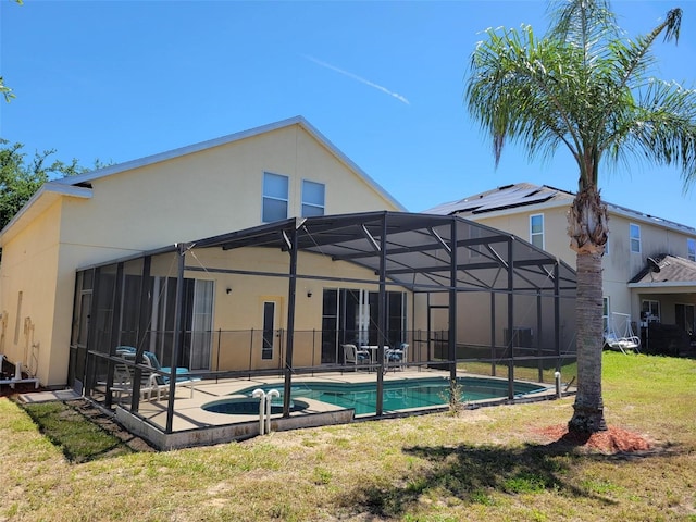 rear view of property with a lanai, a yard, and a patio