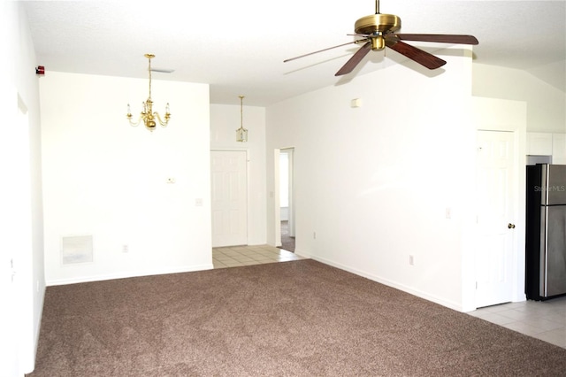 carpeted empty room featuring vaulted ceiling and ceiling fan with notable chandelier