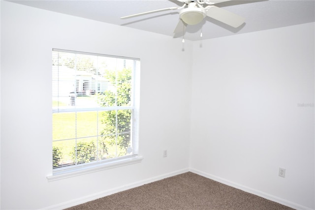 carpeted spare room featuring ceiling fan and a wealth of natural light