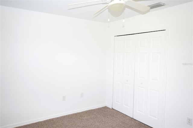 unfurnished bedroom featuring light carpet, a closet, and ceiling fan