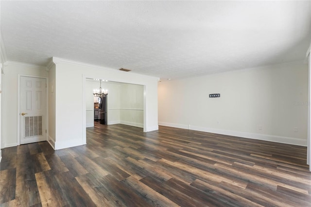 spare room featuring ornamental molding, a notable chandelier, a textured ceiling, and dark hardwood / wood-style flooring