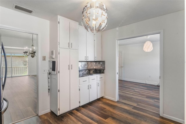 kitchen with white cabinetry, a notable chandelier, a textured ceiling, and dark hardwood / wood-style flooring