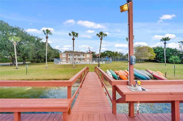 dock area with a yard and a water view