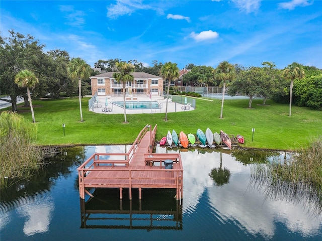 dock area featuring a fenced in pool, a yard, and a water view